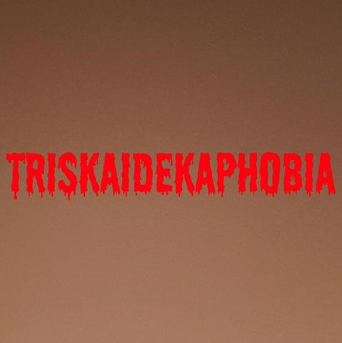 An all caps font, in red and dripping, spells the word "triskaidekaphobia" across the middle of a gradient fleshtone background.
