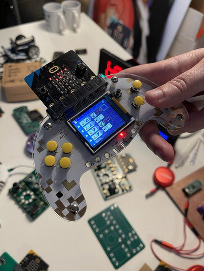 BBC microBit on a custom handheld game controller showing programmable options