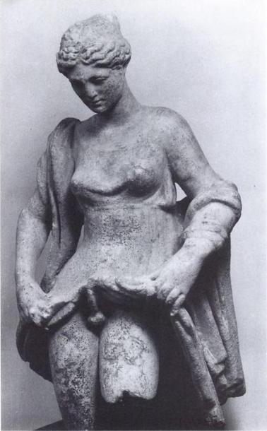 A statue of Aphroditos, lifting the skirt of their dress to reveal an erect phallus.
