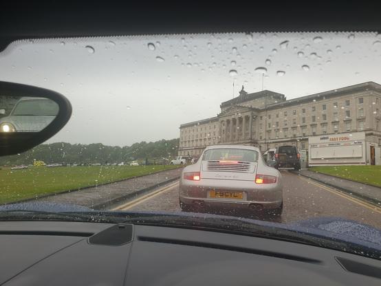 A queue of sports cars heading in to park along the avenue leading up to Stormont.