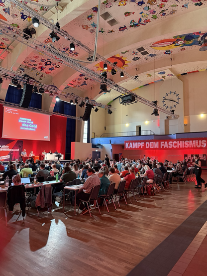 Westbad mit Genossen, Tischen, Bannern, Bühne