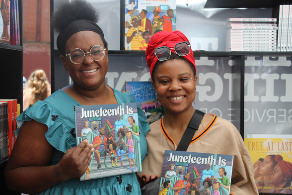 Pamela Pascal and her friend Jade hold up copies of Natasha Tripplett's book Juneteenth Is ...