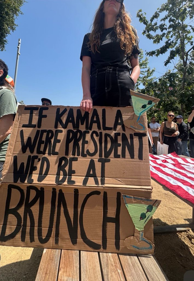 Woman holding a large homemade sign at LA's No Kings protest
Sign says:
If Kamala were President we'd be at brunch