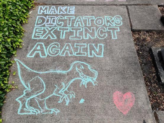 A chalk art drawn on a sidewalk. Lettering reads "Make dictators extinct again" and below that, a tyrannosaur is shown eating a person (a crown falling down off their head) beside a heart.

It's perfect.