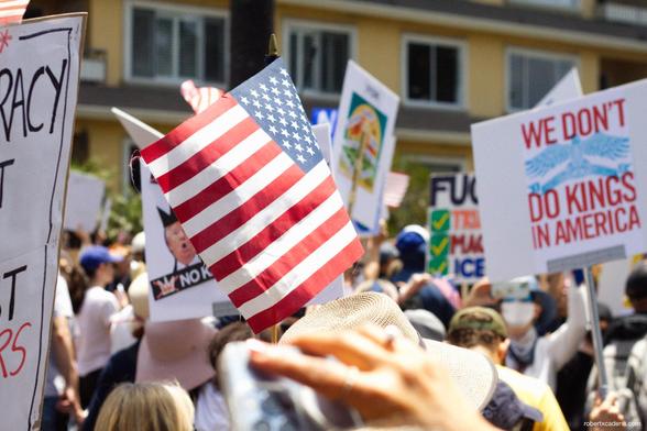 A small American flag held up at a rally
