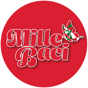 The image features a circular logo with a solid red background. In the center, the text "Mille Baci" is prominently displayed in a stylized, cursive font with a white outline and a red fill. The letters are bold and have a three-dimensional effect, giving them a slightly raised appearance. To the right of the text, there is a graphic of a butterfly with wings patterned in green, white, and red, resembling the Italian flag. The overall design is simple yet eye-catching, with the red background c…