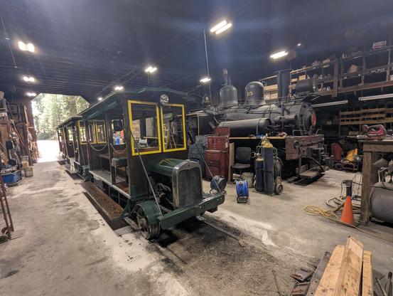 Some old speeders made out of 100 year old cars and a Shay locomotive in an engine house