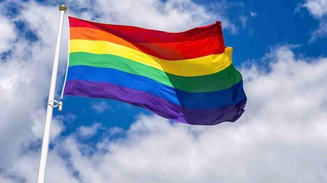 A rainbow flag flying in the air