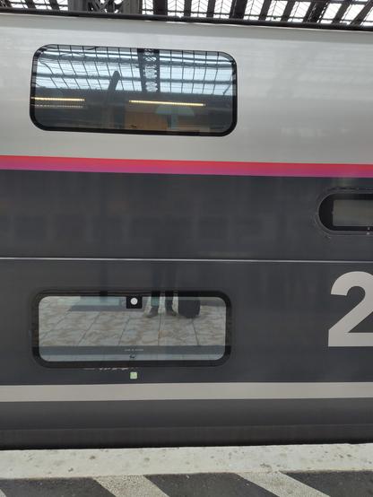 Photo of a train car from exterior. A double deck is recognisable thanks to the narrow windows