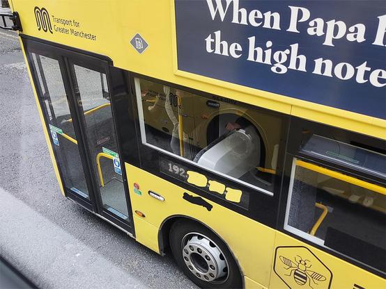Photo of the front nearside of a Manchester Bee Network double decker bus. The bus is painted bright yellow. An electronic display is showing an IP address, although I've masked some of the numbers. 