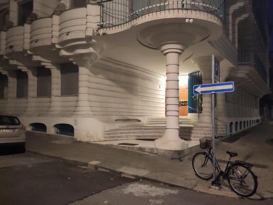 entrance of a residential building made of white stone/concrete (?) cut/molded in curvy shapes