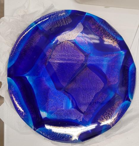 A circular plate of fused glass.  It was made from chunks of a pattern bar of layers of blue and clear glass (photo in previous post to this) - it is several shades of blue and I love it.