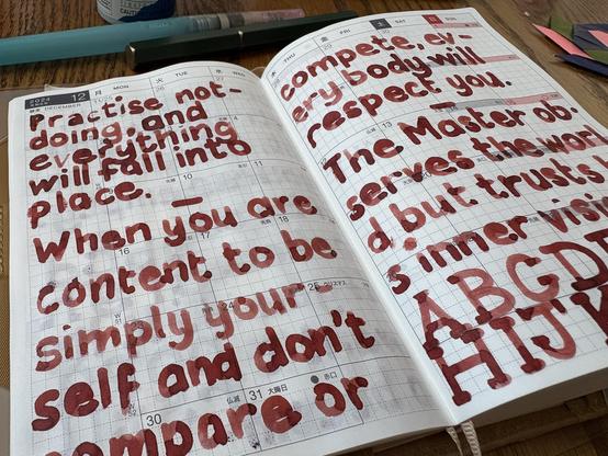 Image of some writing in a journal. The lettering is round and thick, with a lot of color variation. The ink is a dark blood red. The text reads:
Practice not-doing, and everything will fall into place. ~ When you are content to be simply yourself and don’t compare or compete, everybody will respect you. ~ The Master observes the world but trusts his inner vision. ABCDEFGHIJKLM!