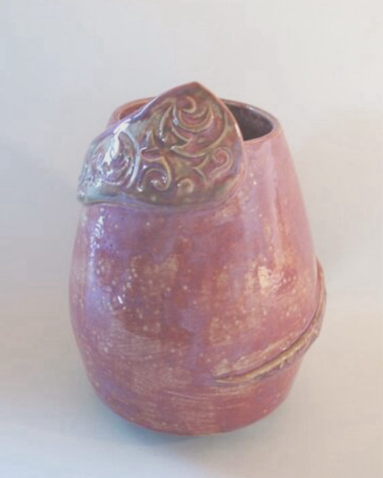 altrosa Vase mit einem Band, das mit einem Muster bedruckt ist. Das Band ist um die Vase gewickelt und wird nach oben immer breiter.