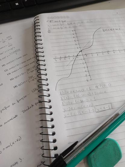 Formulário e caderno. Um gráfico de equação com reta tangente está desenhado.