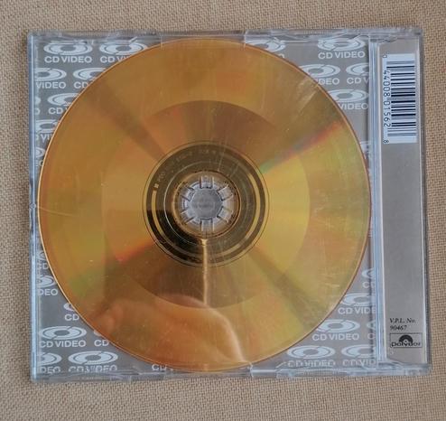 Rear of cd jewel case. Transparent showing gold cd. Distinct banding to show different encoded tracks can be seen