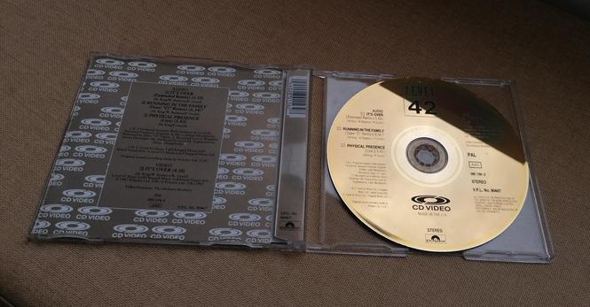 Opened cd jewel case. Booklet on the left, gold cd on the right.