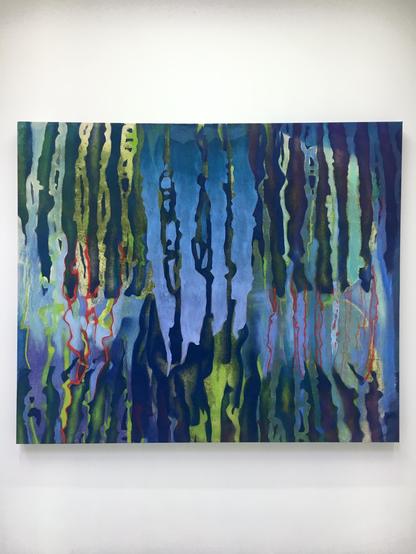 Abstract painting featuring vibrant colors displayed on a white wall, creating a striking visual contrast.
