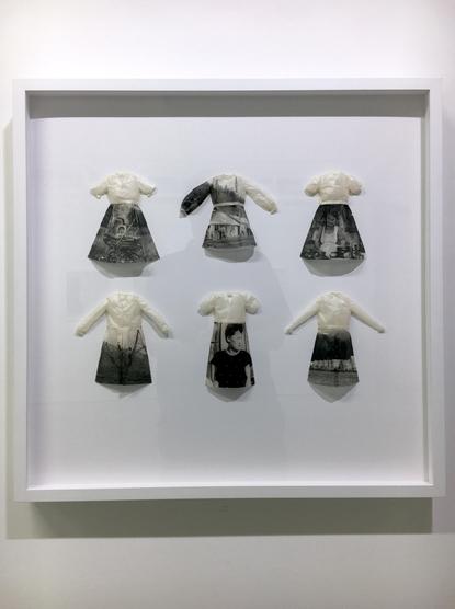 A white-framed series of paper dolls' dresses featuring printed black-and-white images.