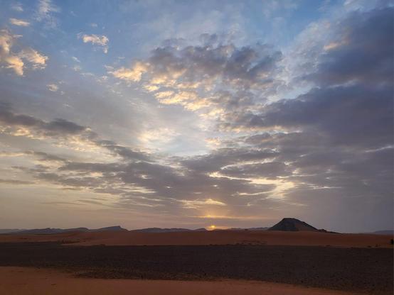Landscape photograph of the Sahara Desert at sunrise in southern Morocco.