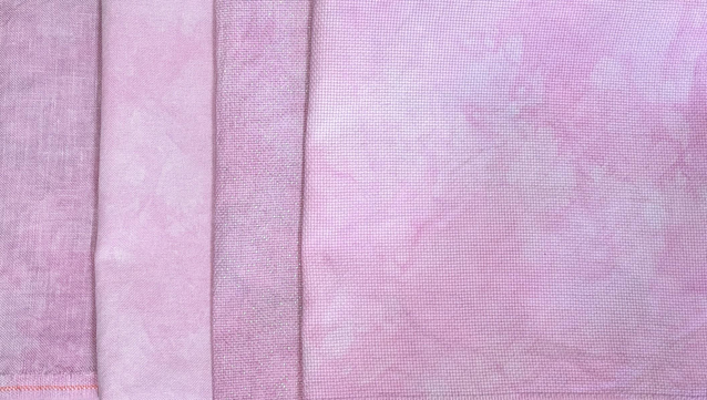 Four pieces of dusty-rose colored fabric - Linen, evenweave, opal Aida, and Aida.