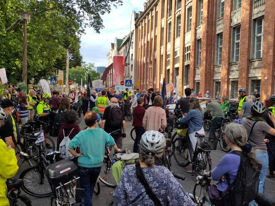 Eine große Gruppe demonstrierender Radfahrender vor der Senatsverwaltung für Umwelt und Verkehr. In der Mitte ist ein Redner zu sehen.