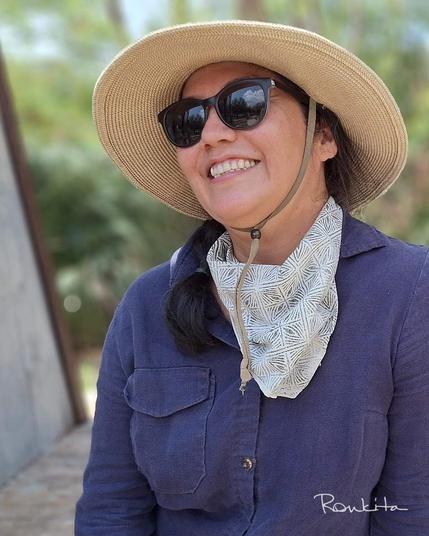 women wearing blue linen shirt, sunglasses, and wide-brimmed hat