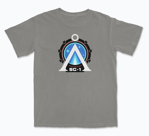 A four color Stargate-inspired design showing the Earth Chevron at the center of the Stargate with the initials SG-1 below it on a tan/grey shirt
