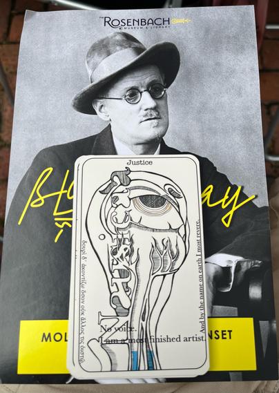Tarot card representing  Episode 13, Nausicaa (Justice), which takes place at 8pm. It depicts an anatomical drawing of an eye and is placed over a photograph of James Joyce. 