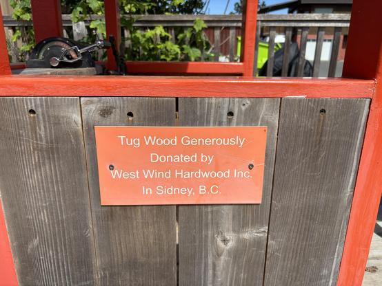 A plaque that says,
"Tug Wood Generously
Donated by
West Wind Hardwood Inc.
Sydney, B.C."