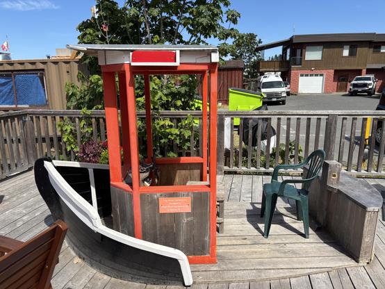 A wider shot of the previous photo revealing a wooden tug boat / playground thing.