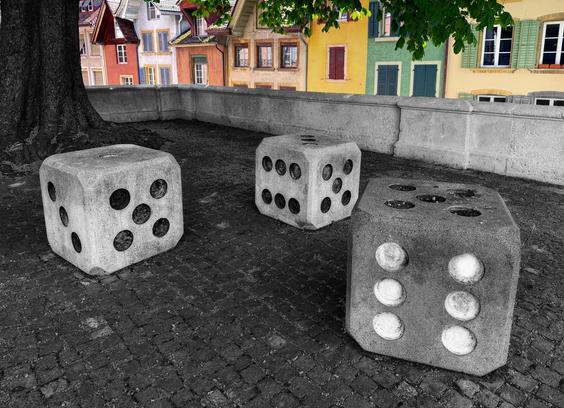 Platz mit Betonwürfeln als Hocker vor einer mehrfarbigen Häuserfront. 