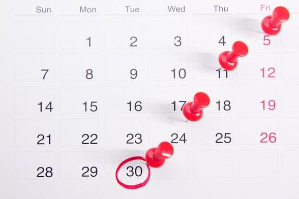 A calendar with red pins in a diagaonal pattern.