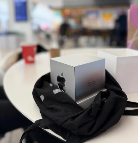 Photo of the Apple design award in a bag on a table. You can see a restaurant  in the background.
