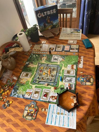 Oltree board game displayed on a orange table, with my handmade orange dice tray and four dices inside it. 