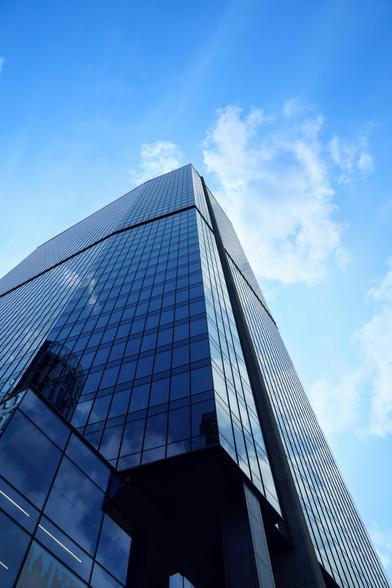 A big, glass facade skyscraper rising towards the blue sky 