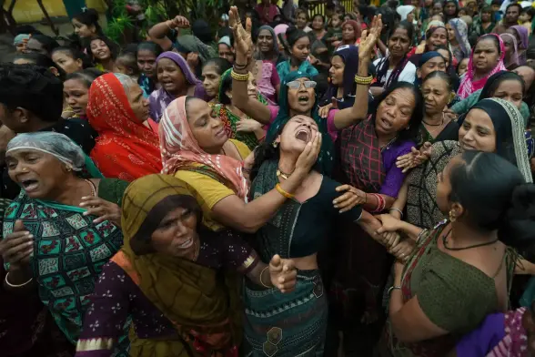 Female family members and friends of Akash Patni, a victim of the Air India plane crash, grieve during his funeral procession.