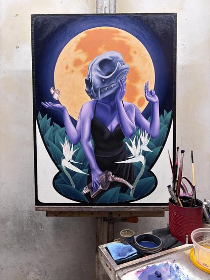 Oil painting in progress of a woman with a lynx skull for a head, with 4 arms. One hand is holding a hose from a gas pump, one hand is on her cheek, one holds up 2 fingers, one is palm up with a zippo lighter floating just above. She is surrounded by plants and bird of paradise flowers. The full moon rises behind her.