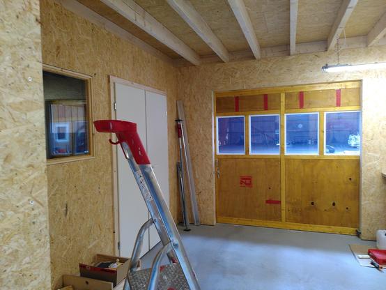 This picture is showing the sliding door and the window and doubled doors to the dyno-room. To the left is a ladder.