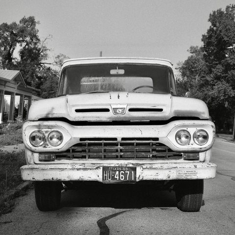 A black and white film photo. A classic 1960 Ford truck chills out on a nice sunny day in Gonzales, Texas. Sunday, June 1, 2025.