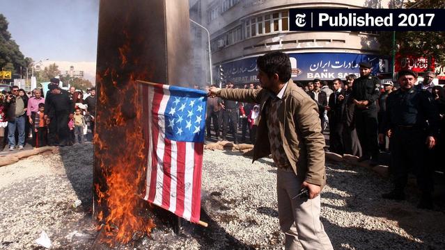 An Iranian man burning a US flag in the street with many onlookers in front of a bank building

Source:
https://static01.nyt.com/images/2017/02/10/world/10iran-1486658636911/10iran-1486658636911-videoSixteenByNineJumbo1600.jpg?year=2017&h=901&w=1600&s=7c01d9e512d627aa1ec976fbad7ac376c96275d1a183bc47987d464d1869e2be&k=ZQJBKqZ0VN&tw=1
