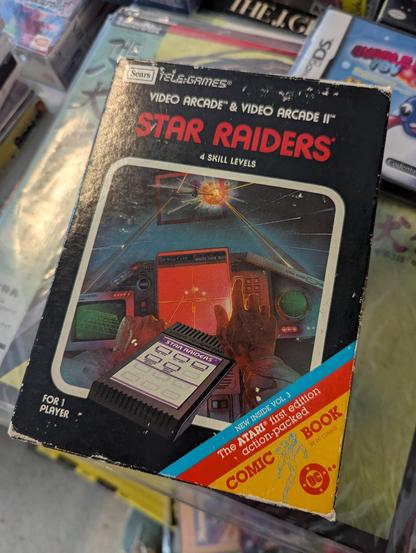 A photograph of "Star Raiders" for the Atari VCS (although here branded as being for the "Sears Telegames"), complete in its original packaging, including the add-on controlle.  It was for sale at the MIT Flea in Cambridge, Massachusetts, USA on 2025.06.15.