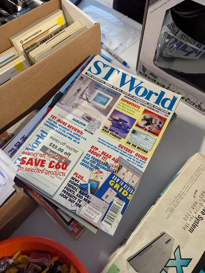 A photograph of a stack of "ST World" magazine, showing prices in British Pounds, for sale at the MIT Flea in Cambridge, Massachusetts, USA on 2025.06.15.