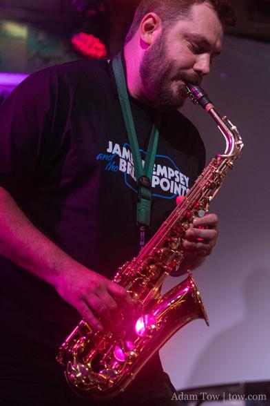Tim Condon playing alto saxophone wearing a JDBP t-shirt. Photo by Adam Tow.