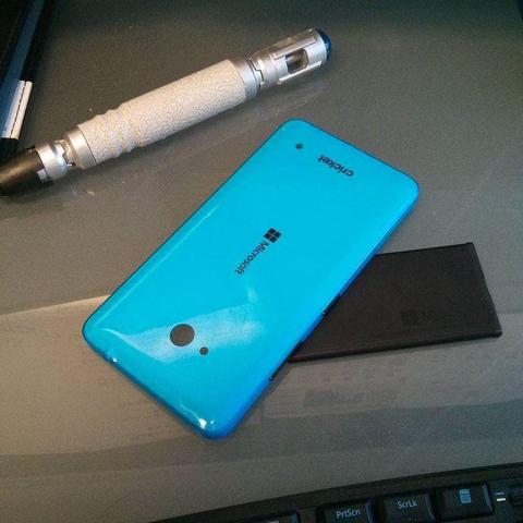 A blue Windows Phone & on a desk, next to a sonic screwdriver from the TV show Doctor Who