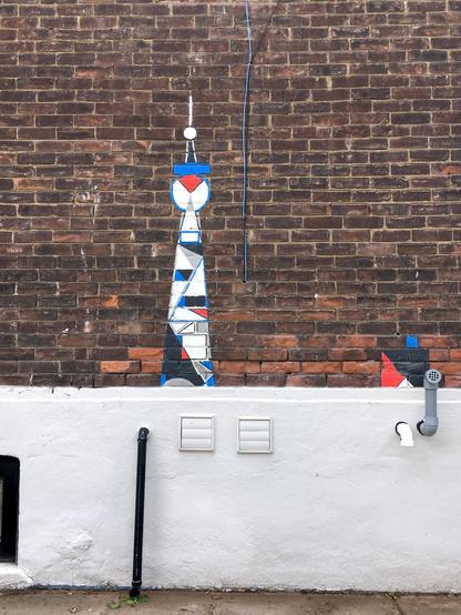 A brick wall featuring a colourful painting of the CN Tower.