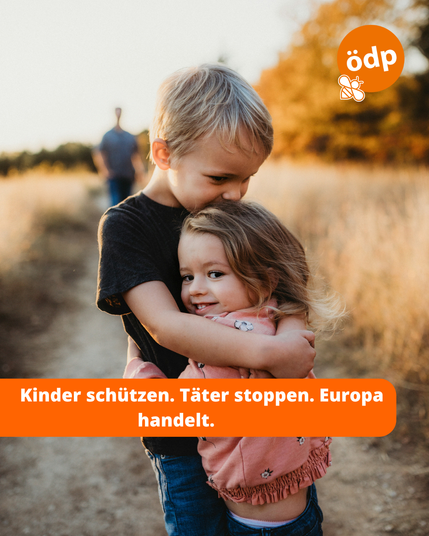 Auf dem Bild sind zwei Kinder zu sehen, die sich umarmen.