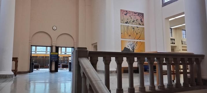 Approaching the main study hall at Wilson/Haggard Library at WWU, showing some decorative romanesque handrails, stairs, and various artworks on the walls