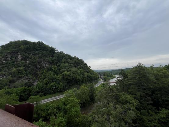standing on the famed Rosendale Trestle Bridge, we see a prominent hill on the left, a highway running beside it, and Roundout Creek beside the highway. The town of Rosendale is in the distance