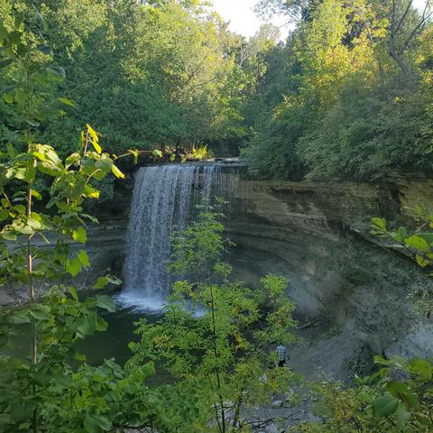 Water falling into a pool with a person visible to the right. Manitoulin Island.